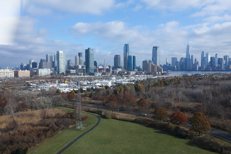Sweeping view of parkland in foreground and tall city buildings in background