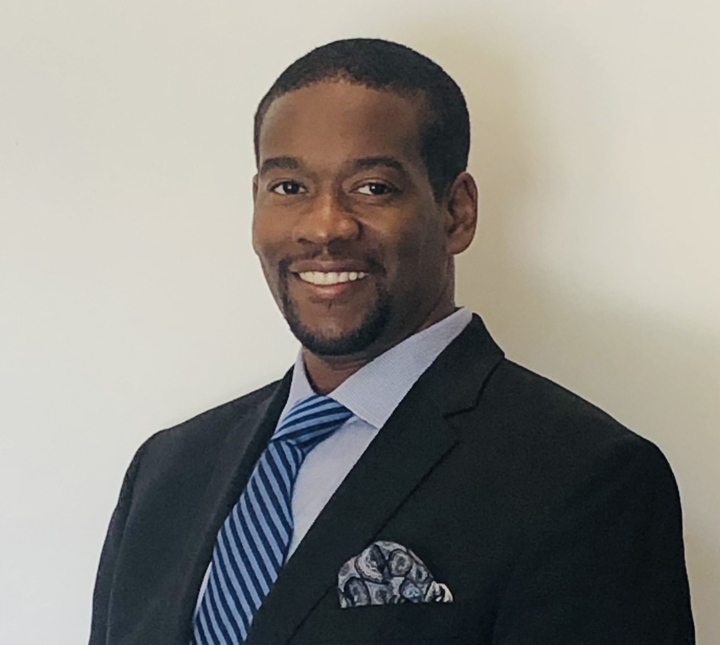 Head shot of smiling Black man in a suit and tie