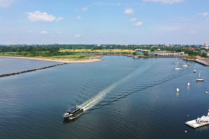 Overhead view of a boat traveling away from a shoreline