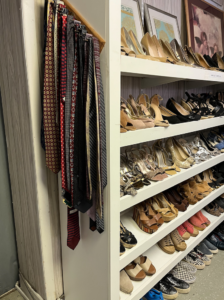 A rack of neckties hangs next to shoes placed on five shelves