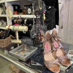 Shoes and jewelry are displayed atop a glass counter