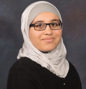 A medium tone, skin woman wearing glasses and a white hijab