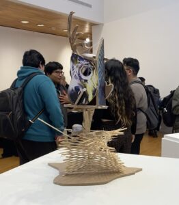 People gather around a sculpture a top a table